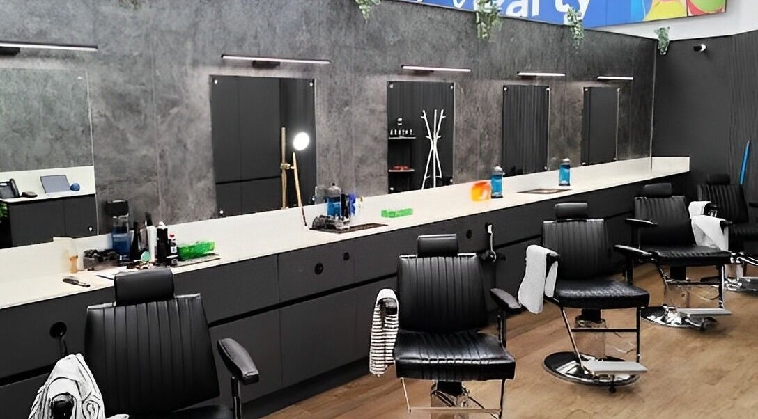 Interior of Gould Barbers Shoreham, Shoreham-by-sea, England, GB, showcasing sleek black chairs and mirrors.
