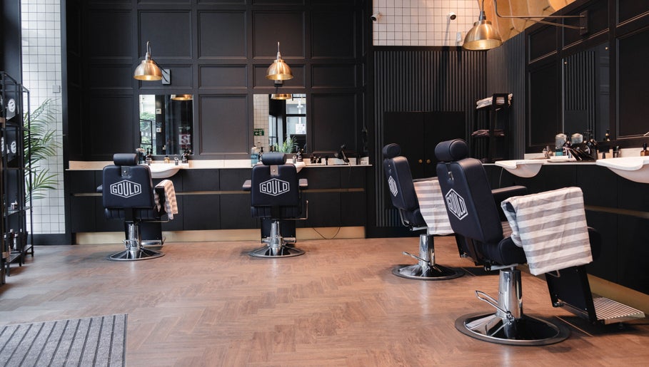 Stylish interior of Gould Barbers London (London Bridge) with sleek barber chairs in London, England, GB.