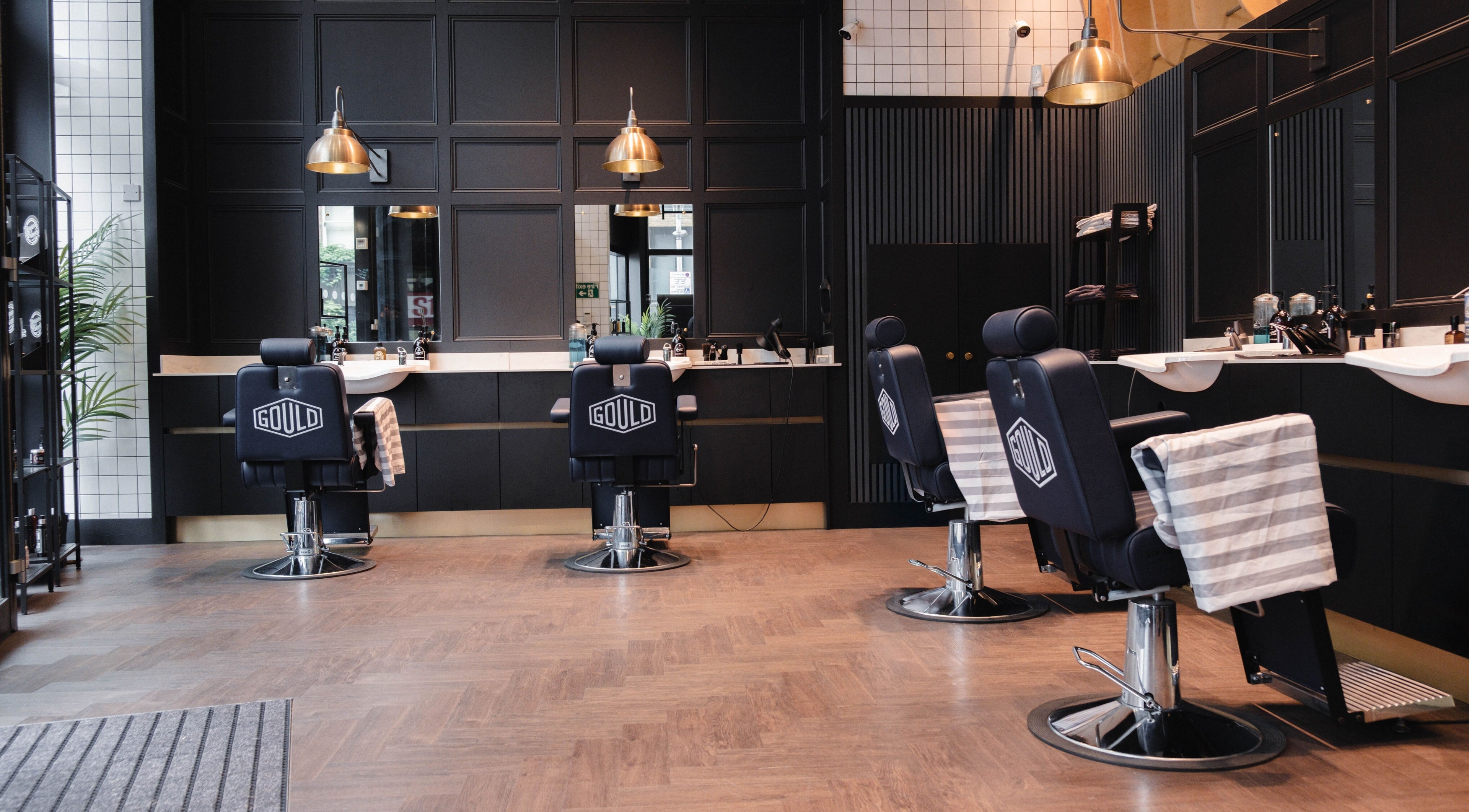 Stylish interior of Gould Barbers London (London Bridge) with sleek barber chairs in London, England, GB.
