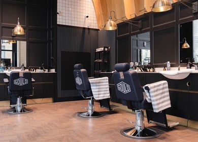 Stylish interior of Gould Barbers London (London Bridge), London, England, GB with modern barber chairs.
