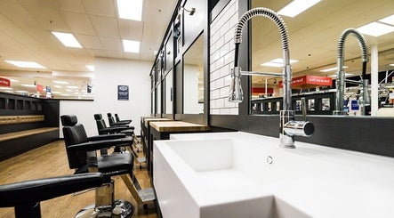Modern barber chairs and sink at Gould Barbers Poole, Poole, England, GB showcasing sleek salon interior.