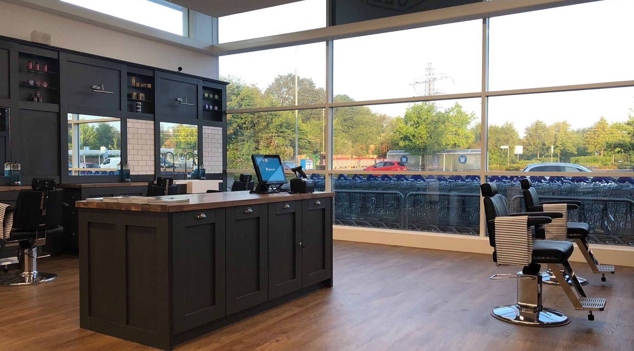Interior of Gould Barbers Poole, Poole, England, GB with sleek barber chairs and large windows.