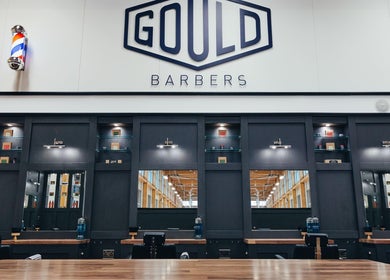Sleek interior of Gould Barbers Stevenage, Stevenage, England, GB with black salon stations and mirrors.