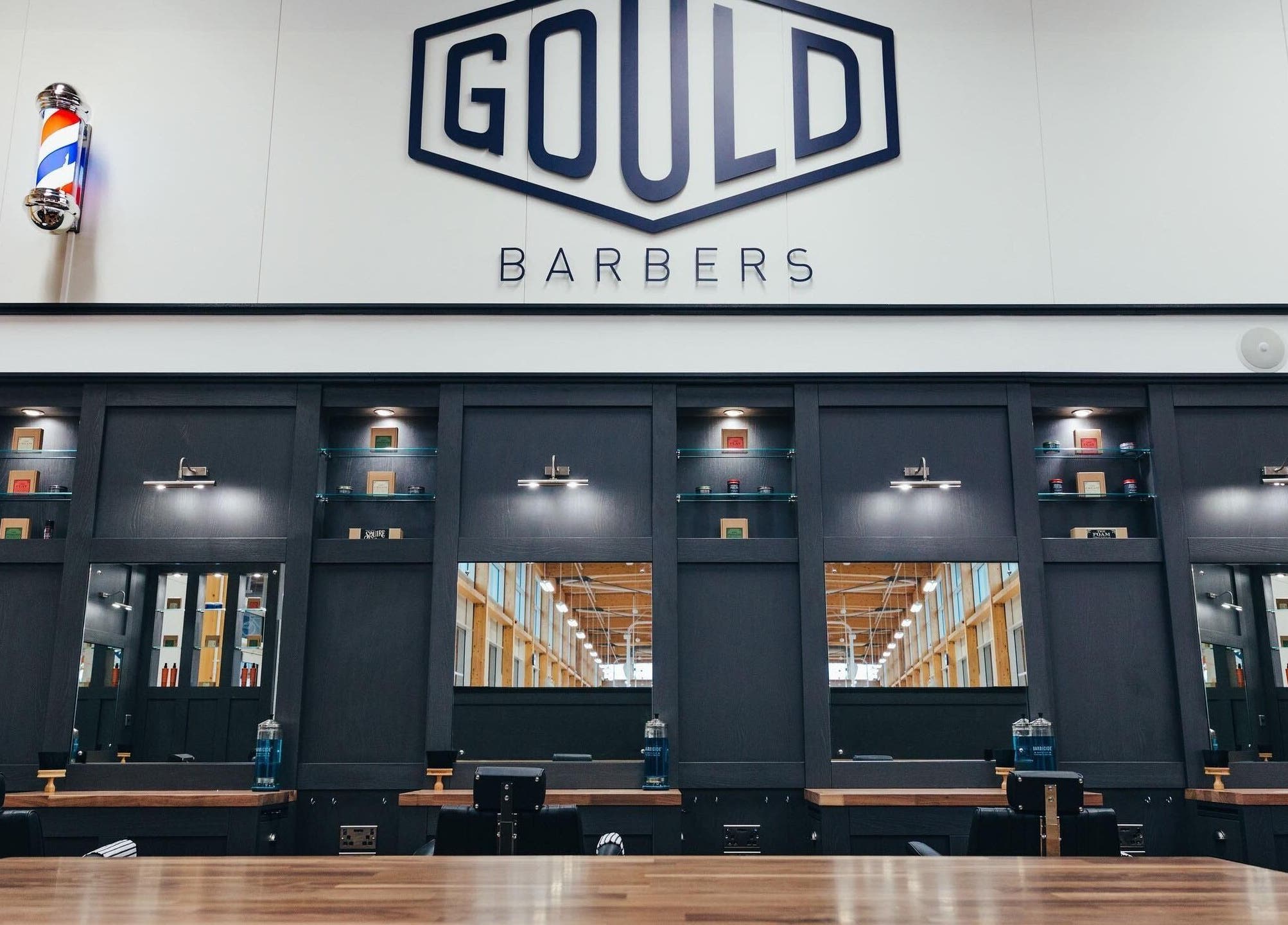 Sleek interior of Gould Barbers Stevenage, Stevenage, England, GB with black salon stations and mirrors.