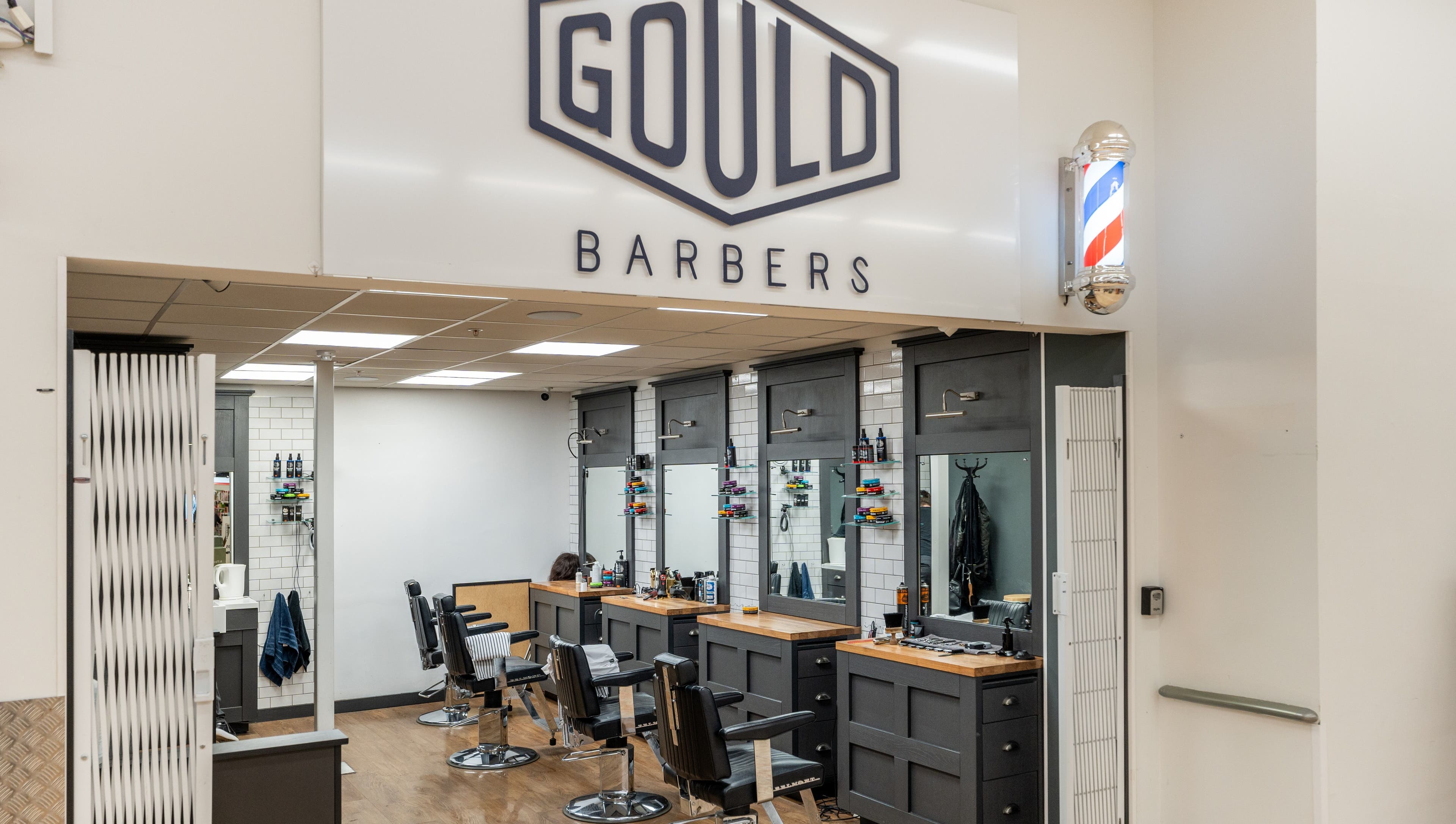 Interior of Gould Barbers Cheshunt, showcasing modern chairs and mirrors in Cheshunt, England, GB.