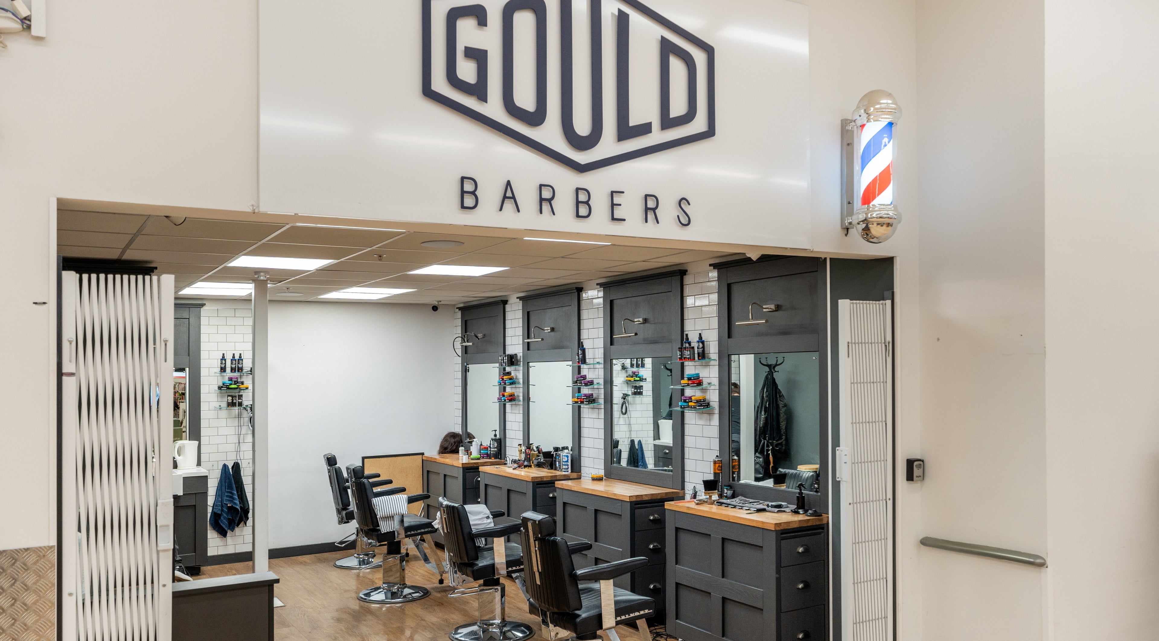 Interior of Gould Barbers Cheshunt, showcasing modern chairs and mirrors in Cheshunt, England, GB.