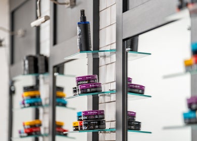 Hair products on glass shelves at Gould Barbers Cheshunt, Cheshunt, England, GB.