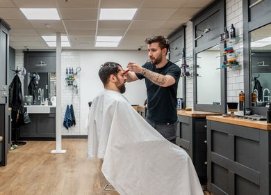 Stylist at Gould Barbers Cheshunt giving a haircut in Cheshunt, England, GB modern barbershop interior.