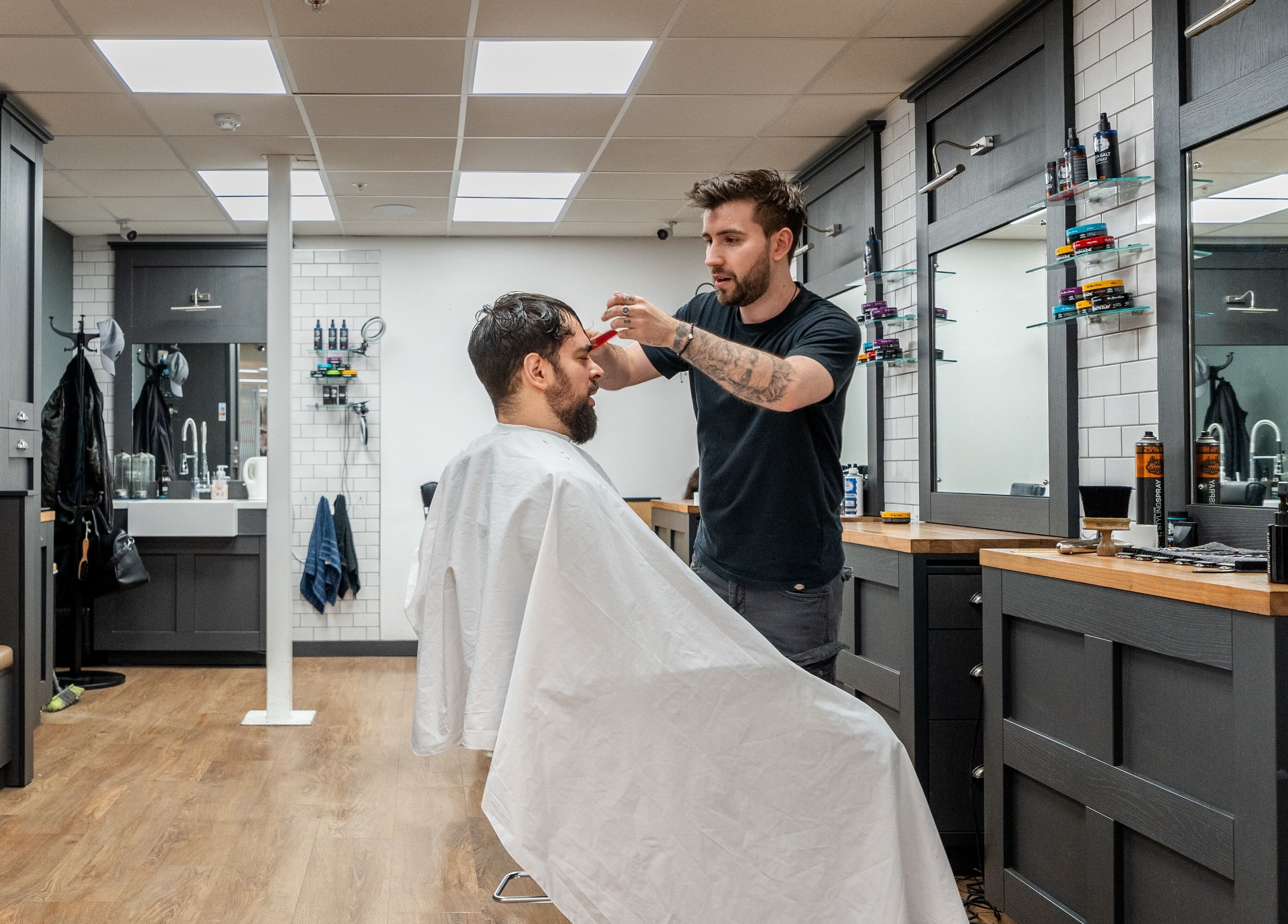 Stylist at Gould Barbers Cheshunt giving a haircut in Cheshunt, England, GB modern barbershop interior.