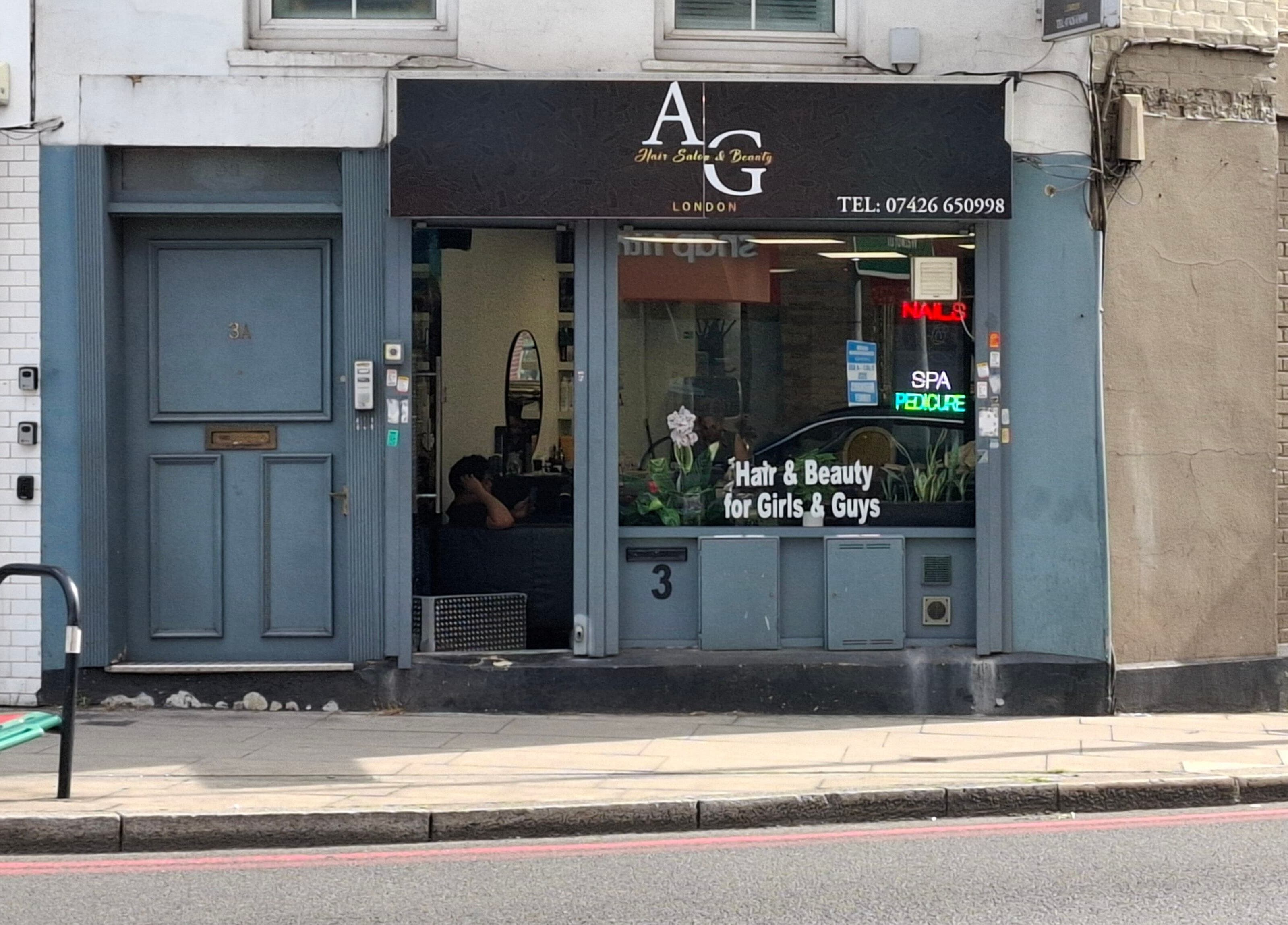 Exterior of AG Hair Salon in London, England, GB, featuring stylish storefront and neon beauty signs.