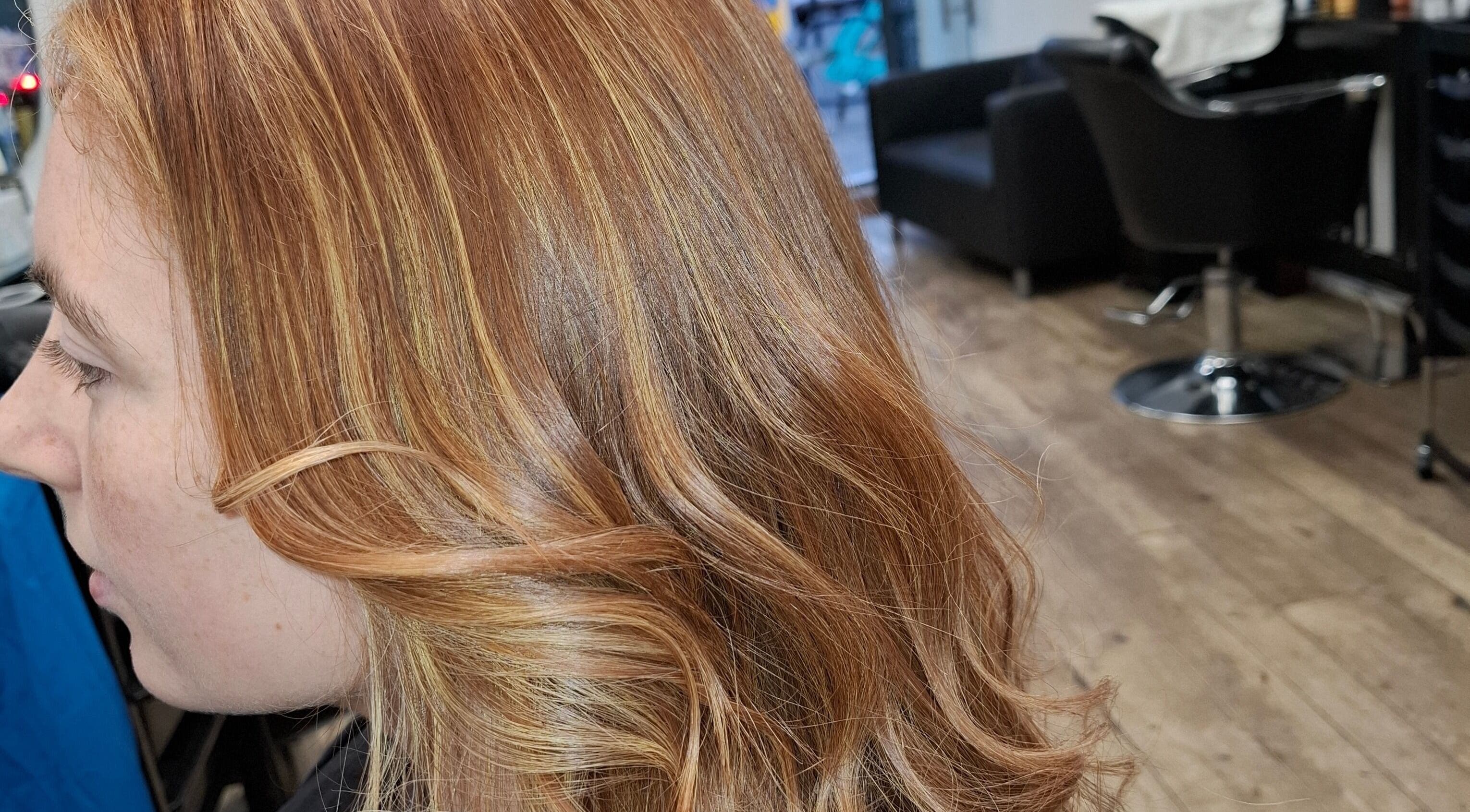 Golden wavy hair styled at AG Hair Salon, London, England, GB. Vibrant look with elegant curls.