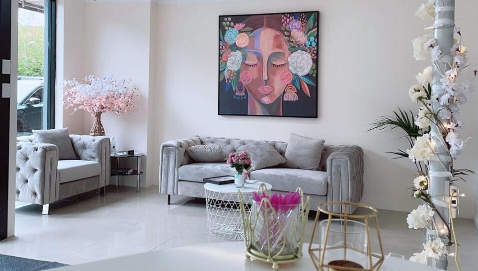 Elegant waiting area at Galaxy Lashes in Melbourne, Victoria, AU featuring chic sofas and vibrant artwork.