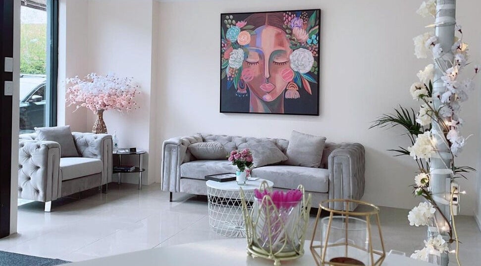 Elegant waiting area at Galaxy Lashes in Melbourne, Victoria, AU featuring chic sofas and vibrant artwork.