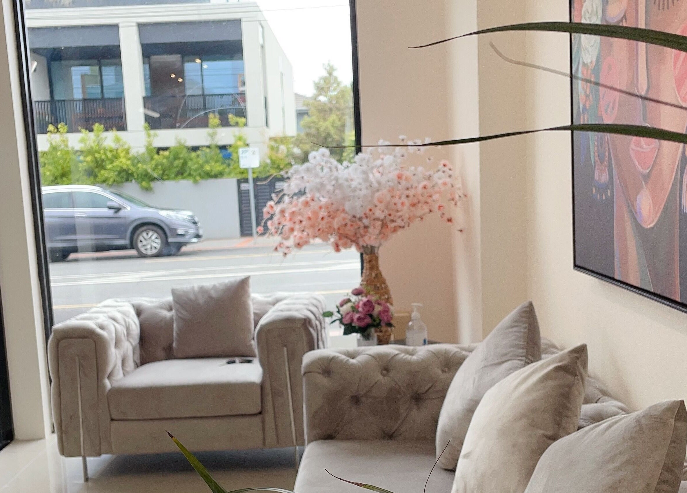 Cozy seating area at Galaxy Lashes, Melbourne, Victoria, AU, featuring plush sofas and floral decor.