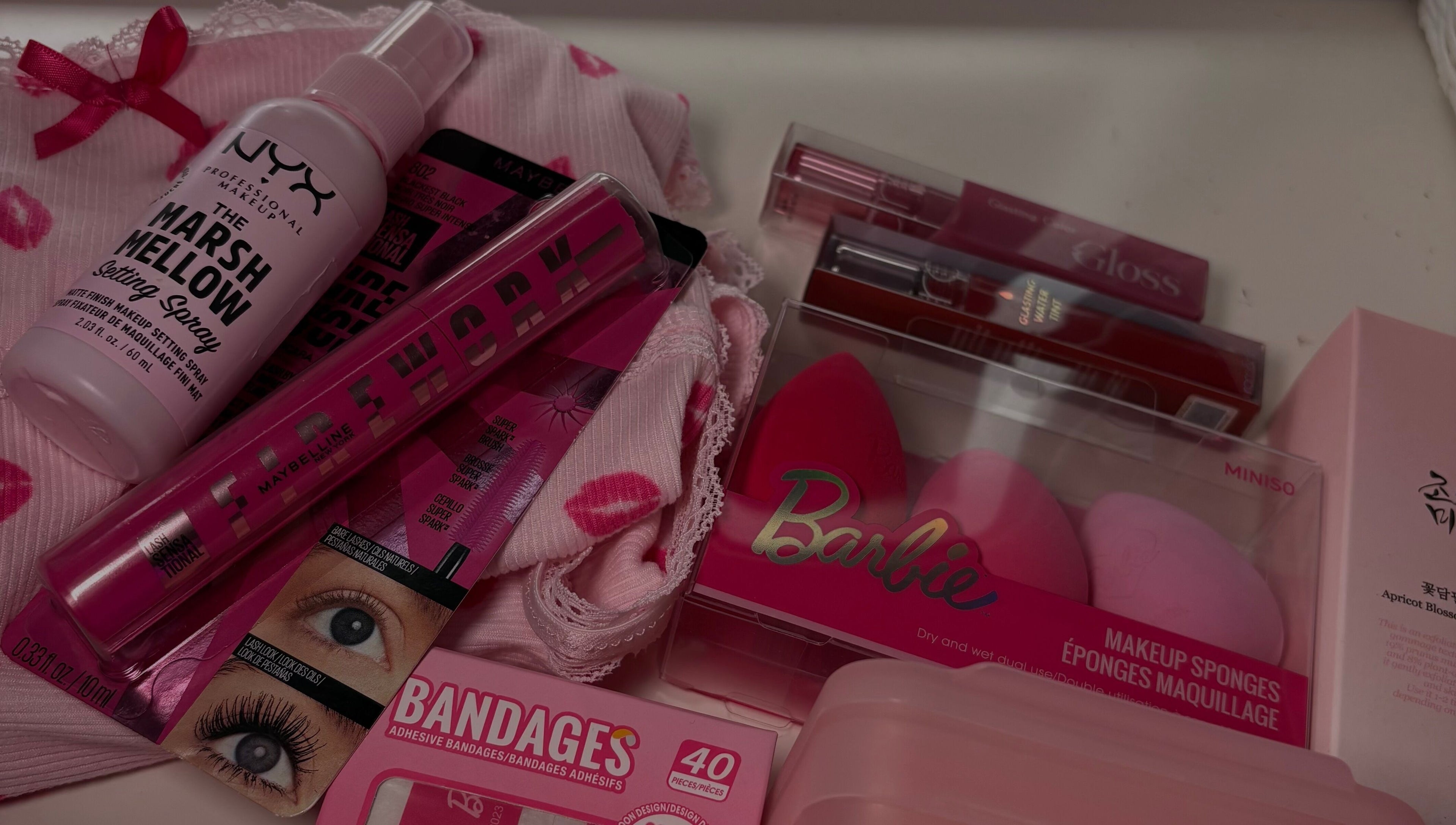 Variety of pink beauty products at LAU, Toronto, Ontario, CA, including makeup sponges and setting spray.