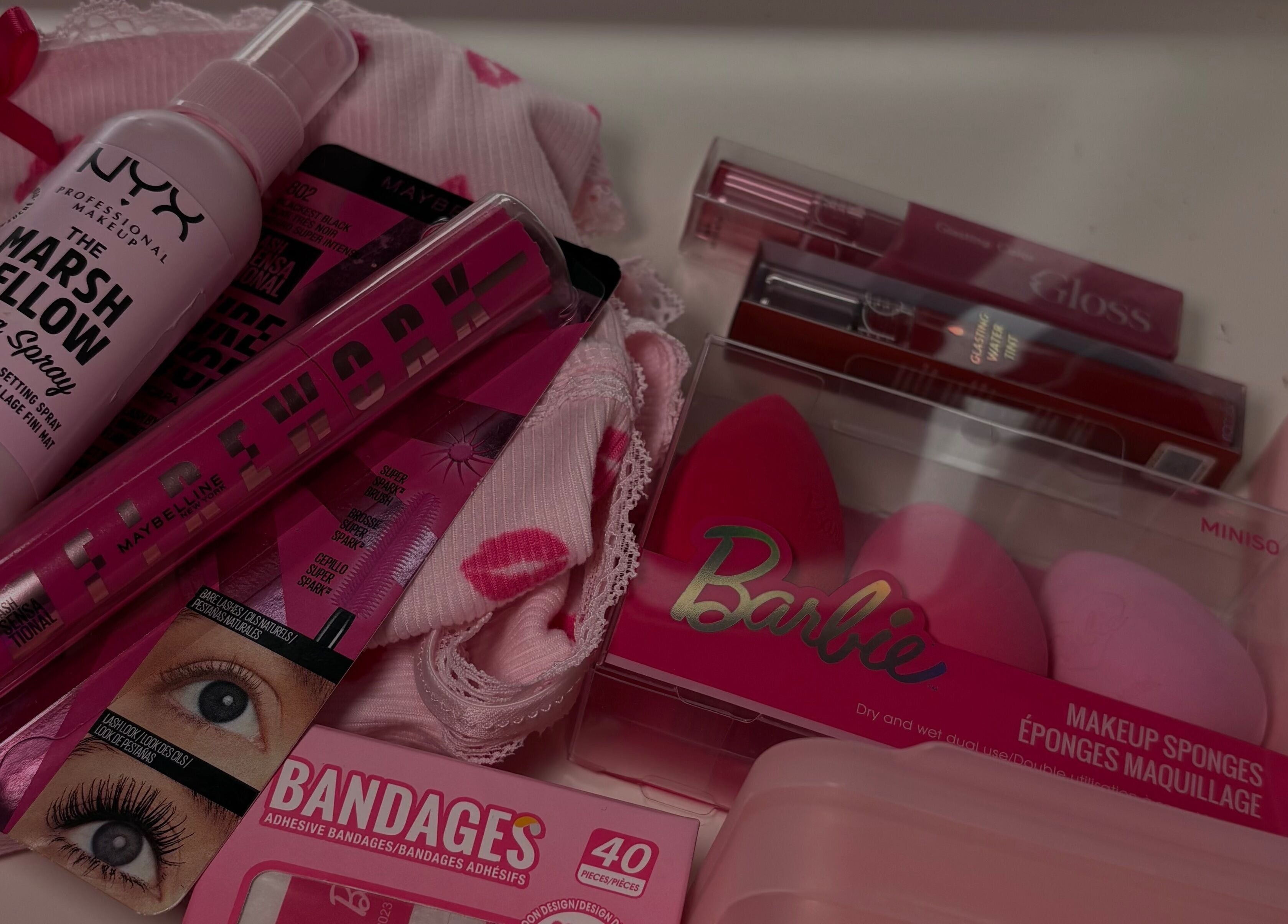 Variety of pink beauty products at LAU, Toronto, Ontario, CA, including makeup sponges and setting spray.