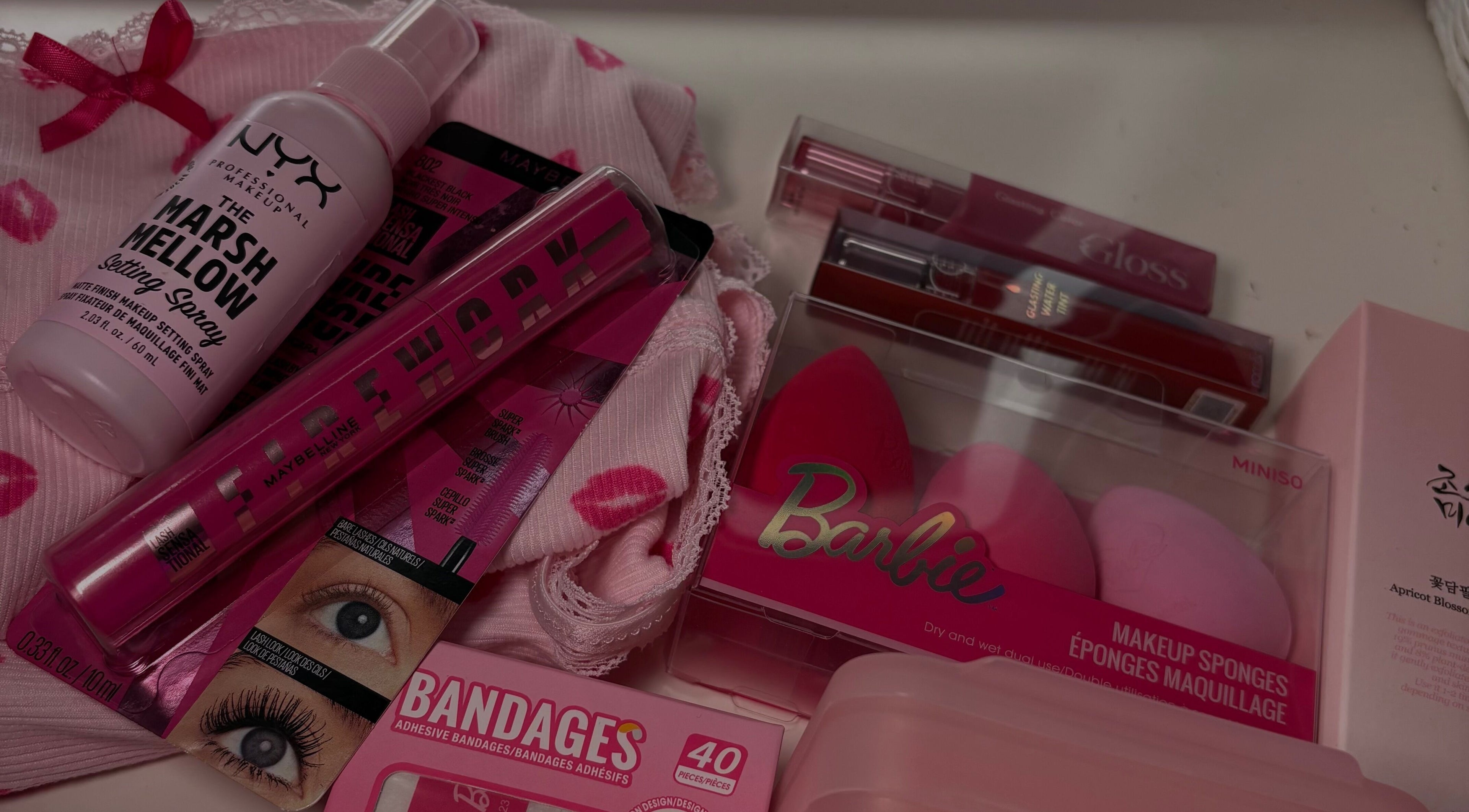 Variety of pink beauty products at LAU, Toronto, Ontario, CA, including makeup sponges and setting spray.