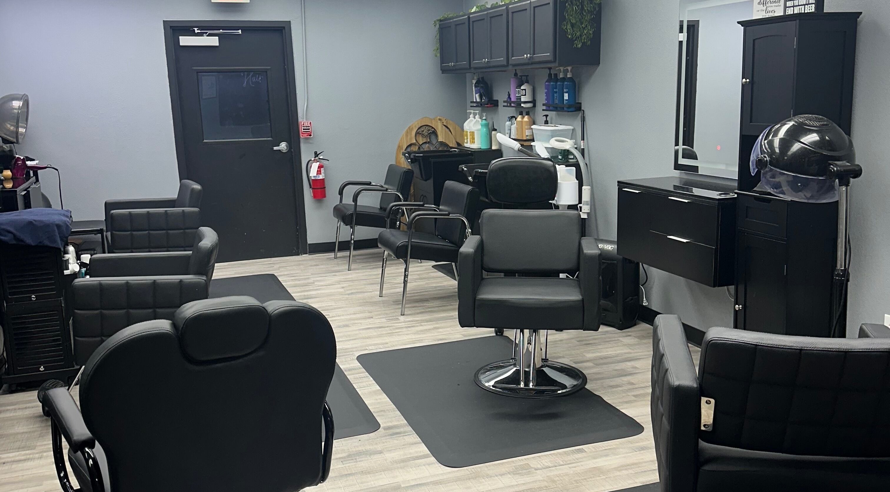 Modern interior of Jay Fields - PhenomHair in Forney, Texas, US with sleek black styling chairs.