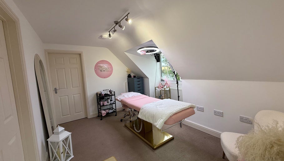 Relaxing treatment room at Livvie’s Beauty Marlborough, England, GB with a pink bed and soft lighting.