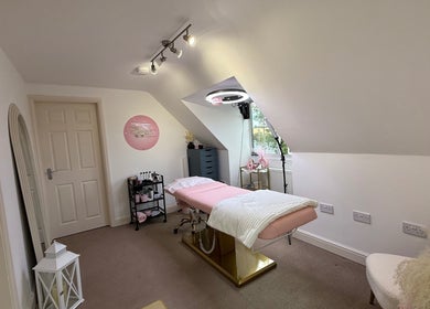 Relaxing treatment room at Livvie’s Beauty Marlborough, England, GB with a pink bed and soft lighting.