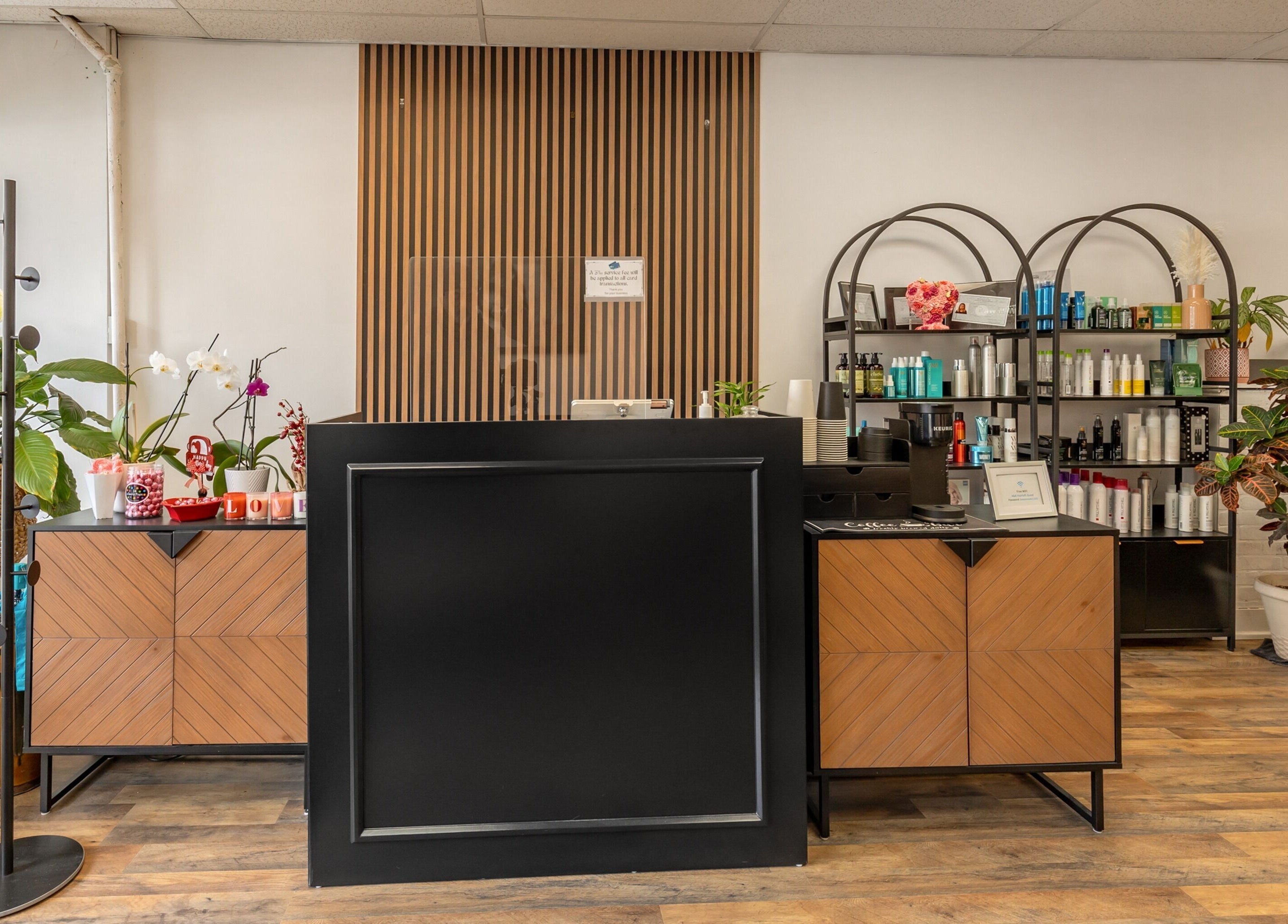 Reception area at A&A Hairloft in Mineola, New York, US, showcasing modern decor and beauty products.