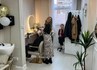 Stylish interior of Hair By Grace Crofton in Hoylake, England, GB, featuring a hair stylist at work.