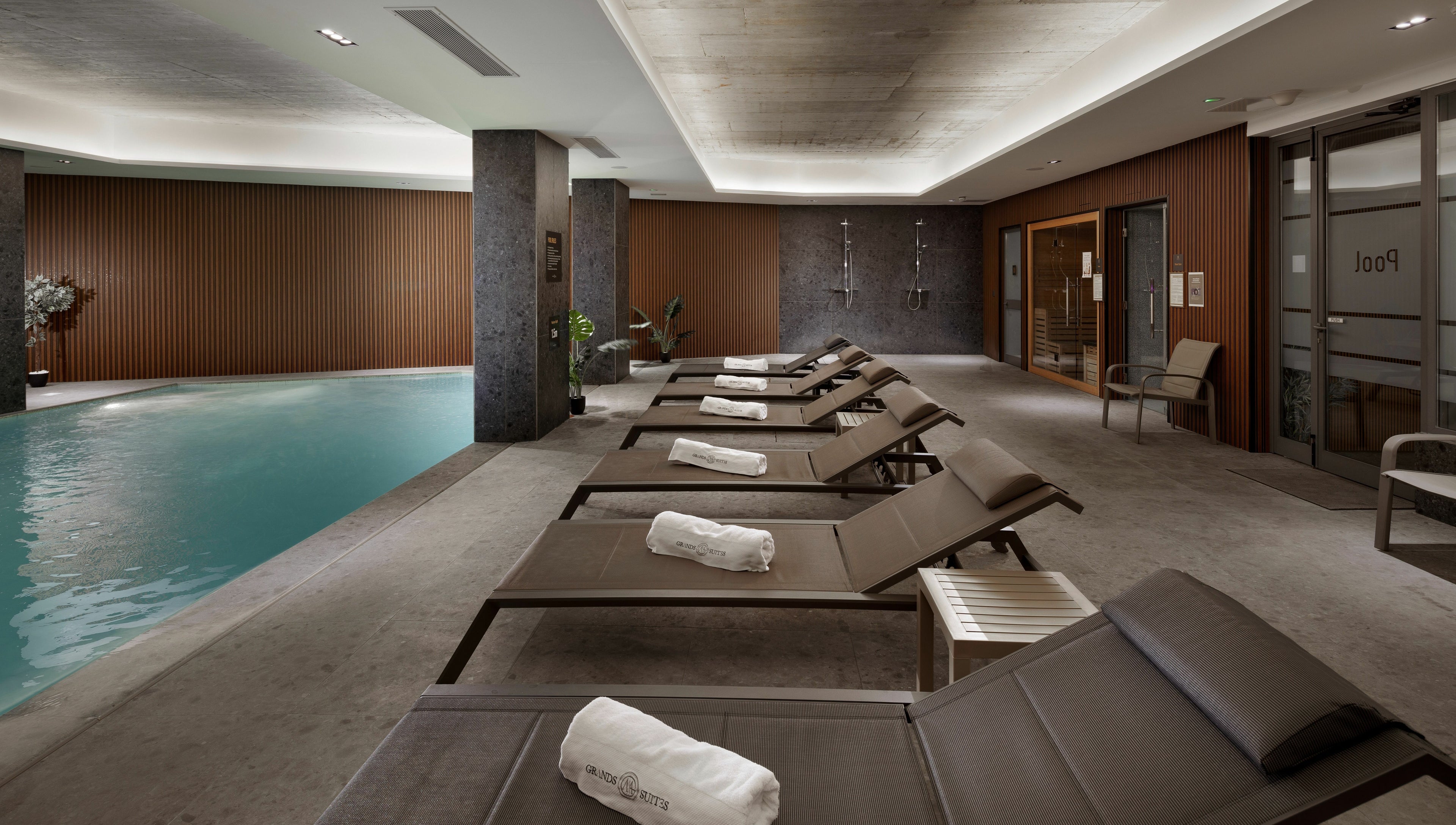 Relaxing poolside at Ease Spa, Gzira, MT with lounge chairs and soft lighting for a tranquil experience.