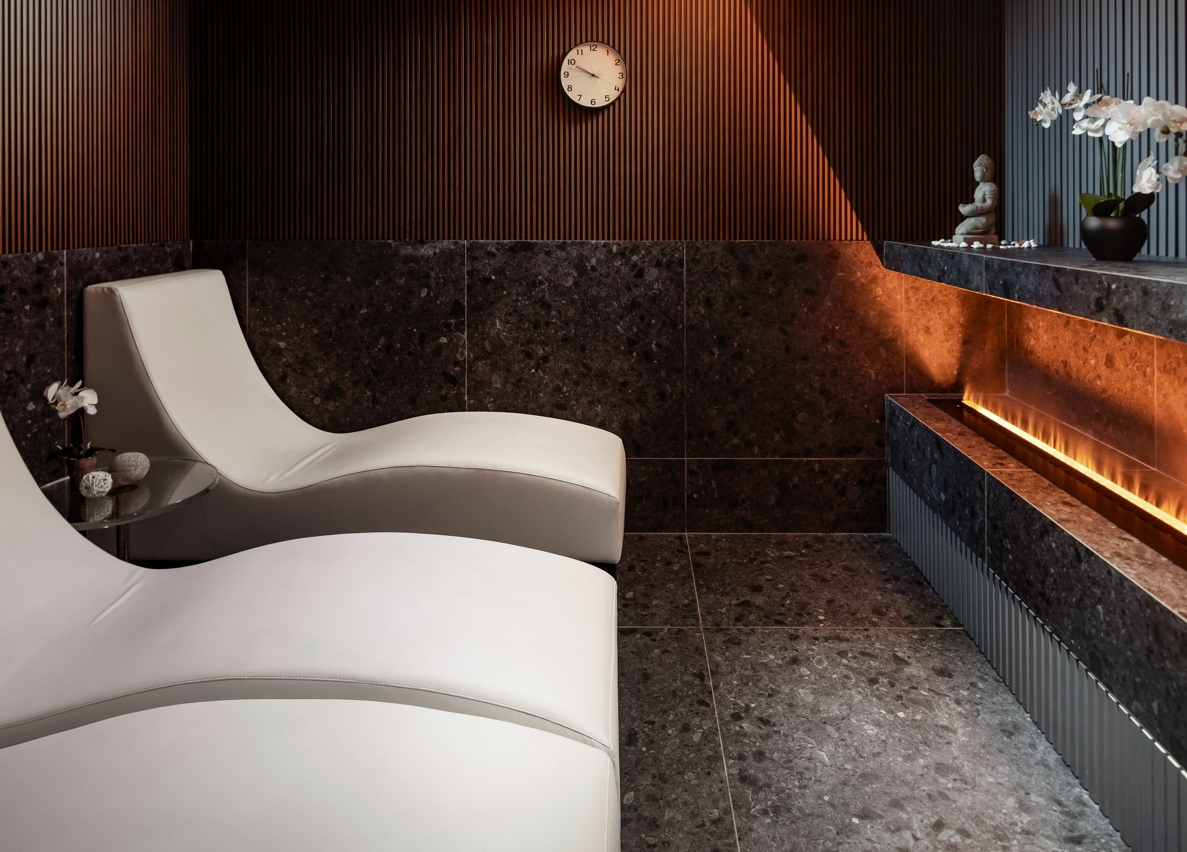 Luxurious lounge at Ease Spa, Gzira, MT featuring sleek chairs and ambient decor.