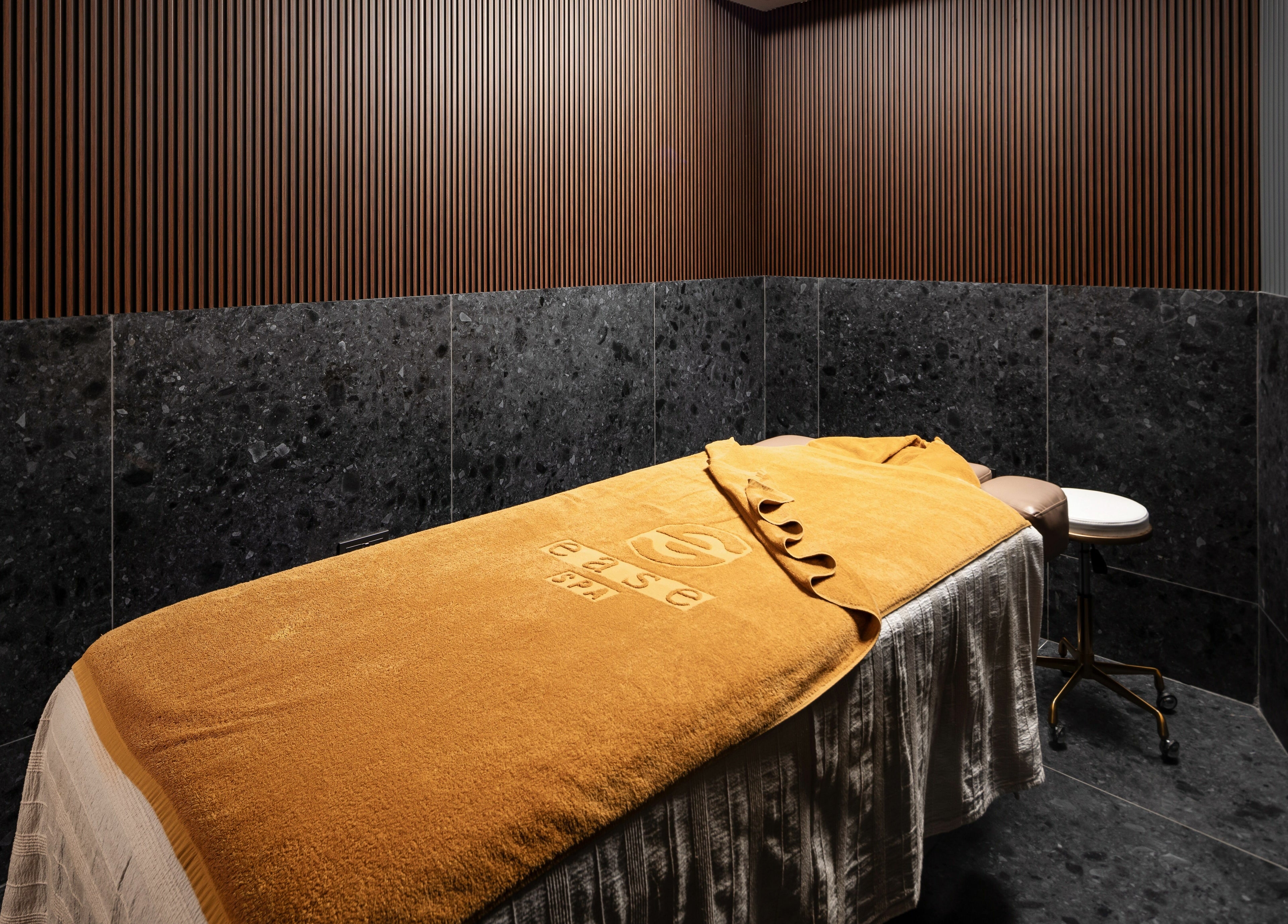 Relaxing treatment room at Ease Spa in Gzira, MT, featuring a luxurious bed and calming ambiance.