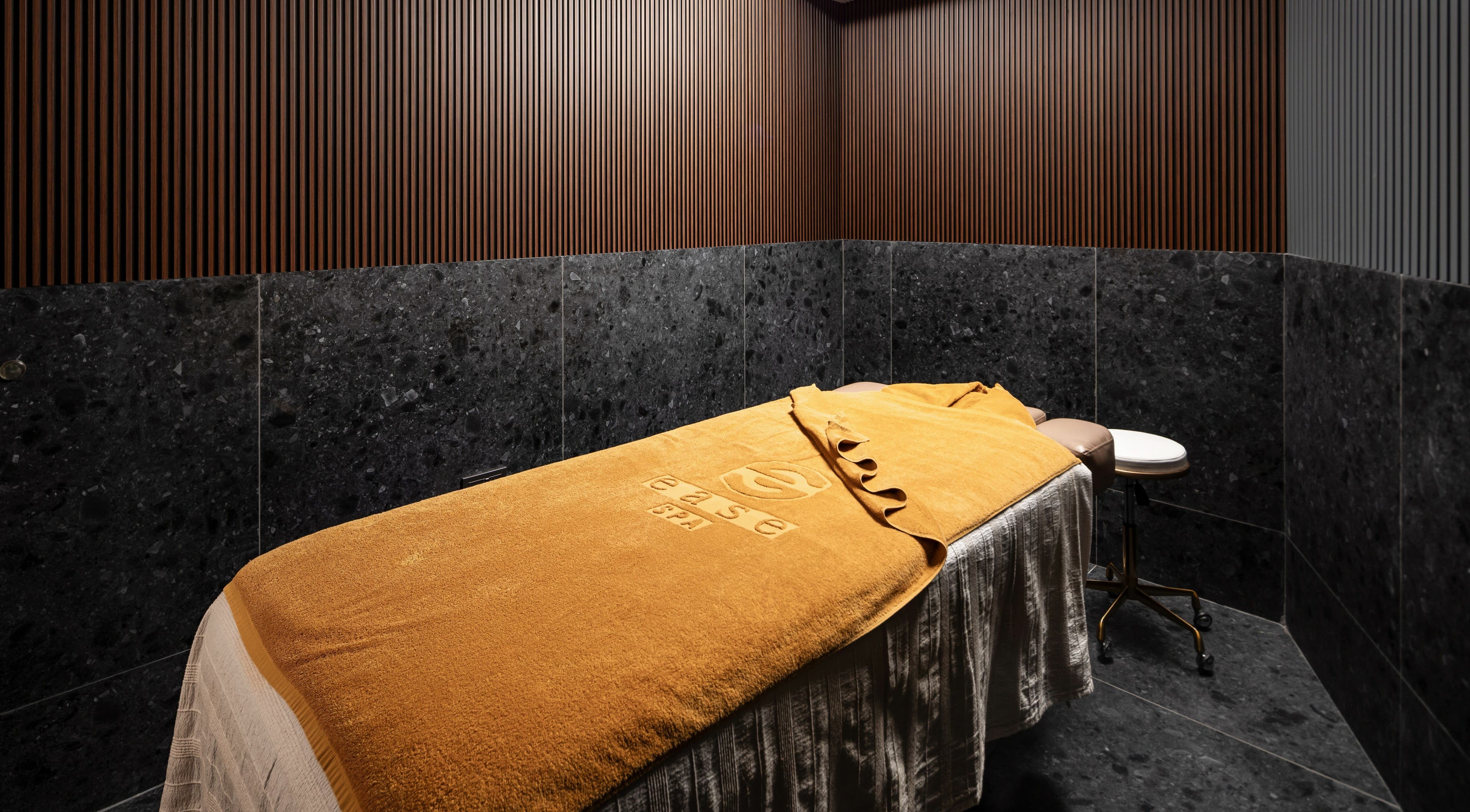 Relaxing treatment room at Ease Spa in Gzira, MT, featuring a luxurious bed and calming ambiance.