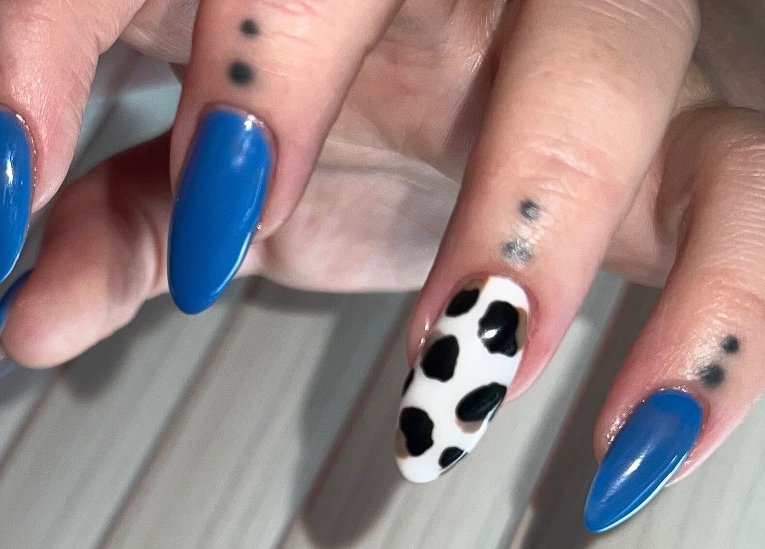 Vibrant blue and cow print nails at Nailed You By Lou, Stockport, England, GB, showcasing unique nail art.