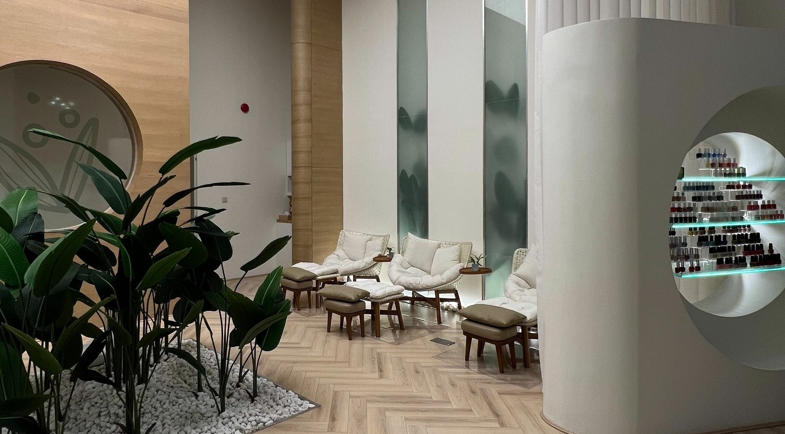 Chic seating area with plush chairs at Buff Nail Spa, Riyadh, SA, surrounded by greenery.