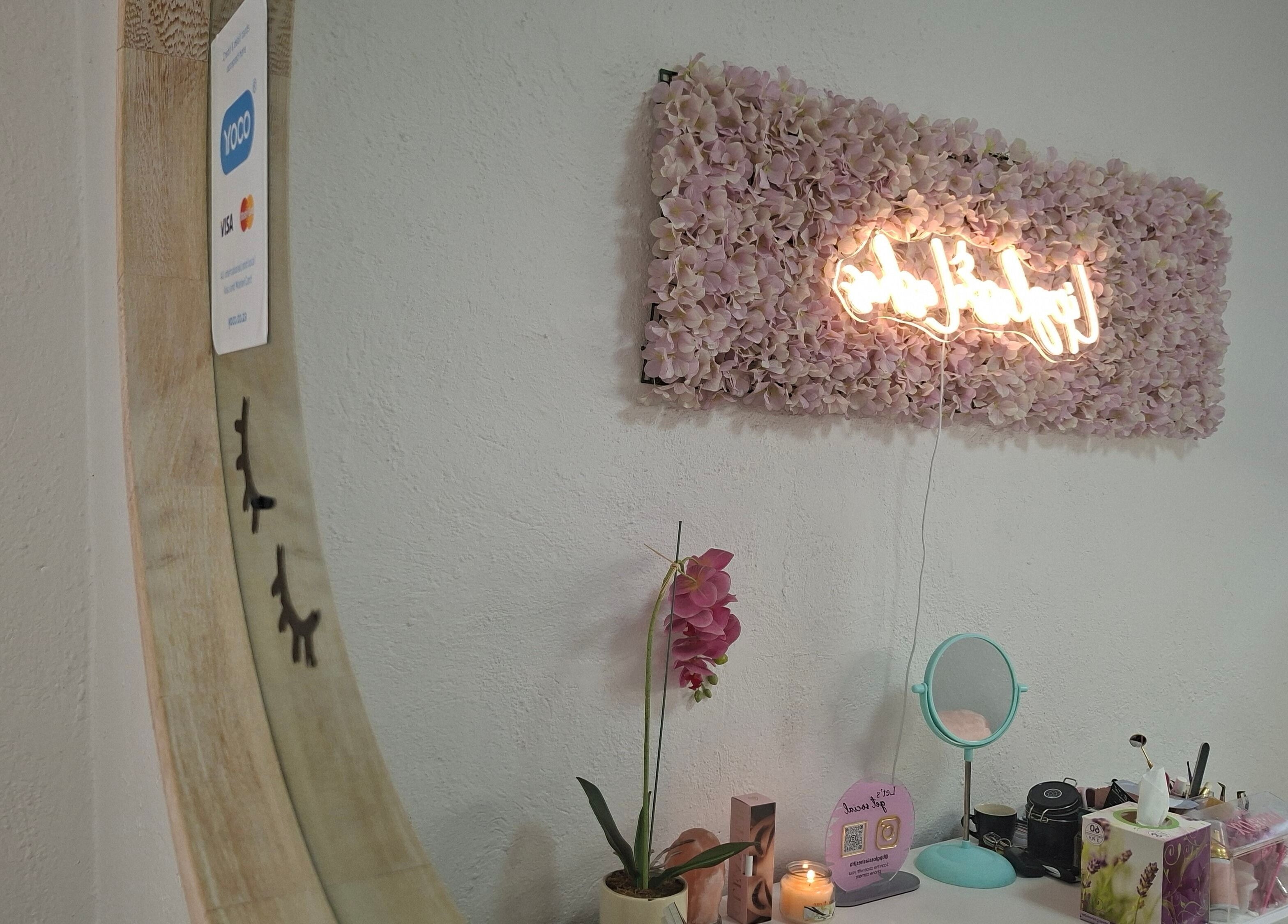 Stylish neon sign on floral wall at Lipgloss and Lashes Woodmead, Sandton, Gauteng, ZA enhancing a chic beauty space.