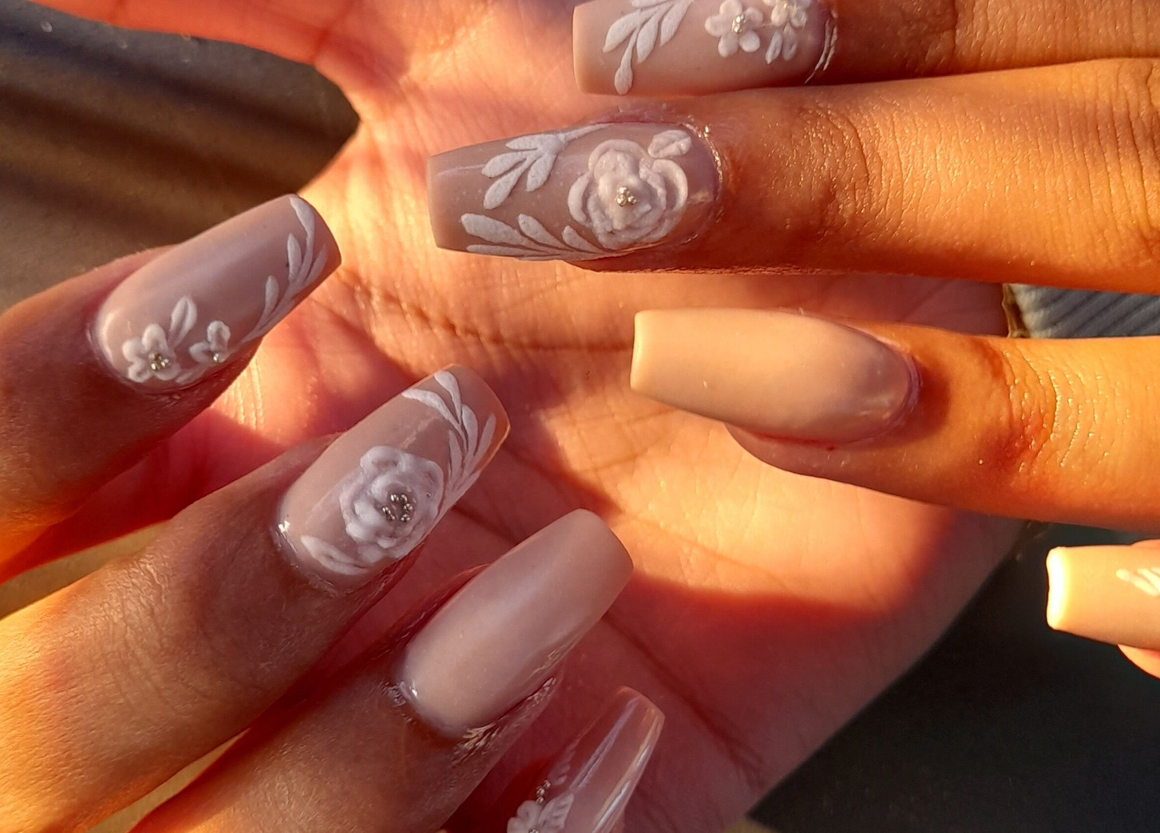 Detailed floral nail art at michdylan, Benoni, Gauteng, ZA, showcasing intricate white designs.