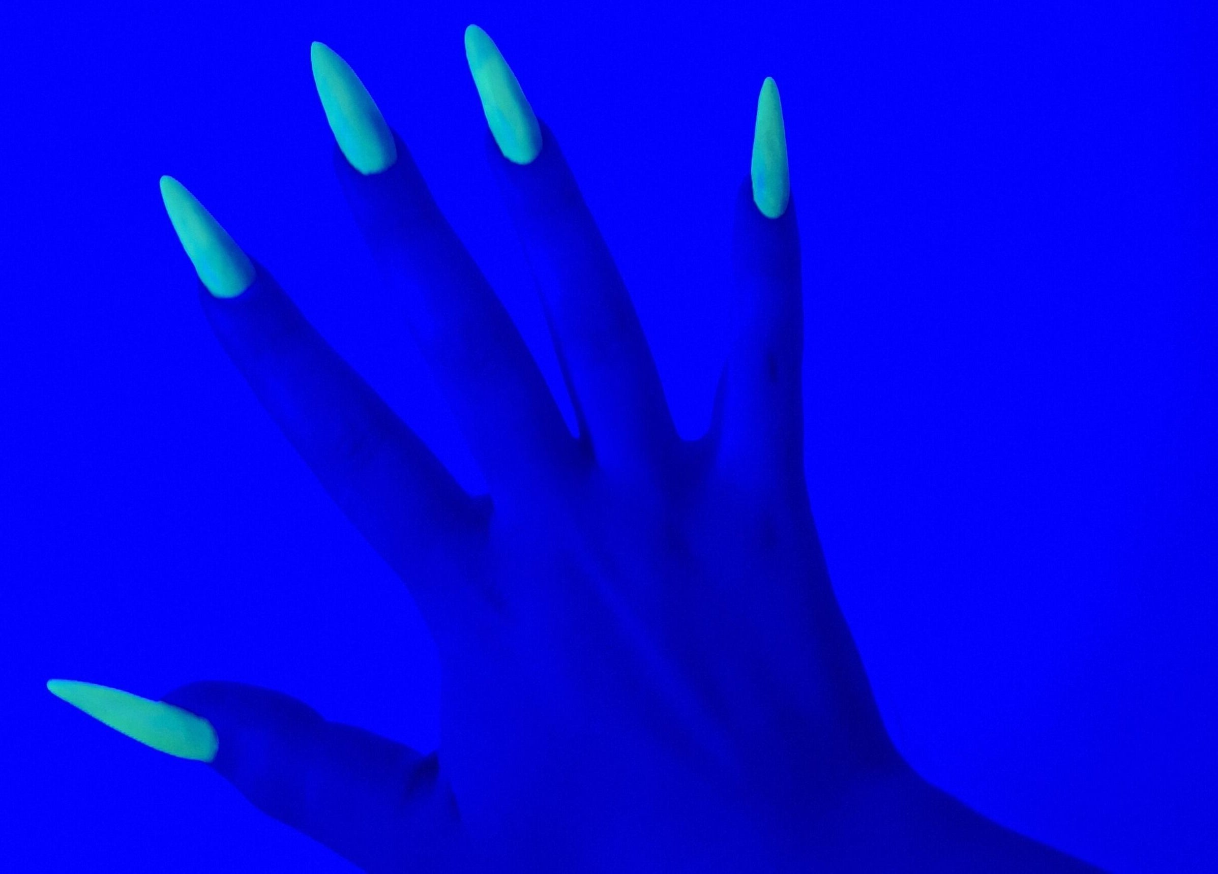 Neon glowing nails under blue light at michdylan in Benoni, Gauteng, ZA. A modern touch of beauty.
