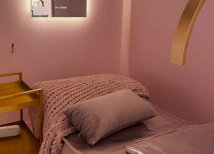 Cozy pink therapy room at The Glam Lab in Richmond, British Columbia, CA, with plush bedding and soft lighting.