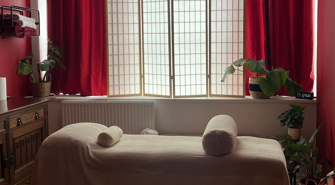Relaxing massage room at The Talking Body Clinic, Glasgow, Scotland, GB with plush bed and ambient lighting.