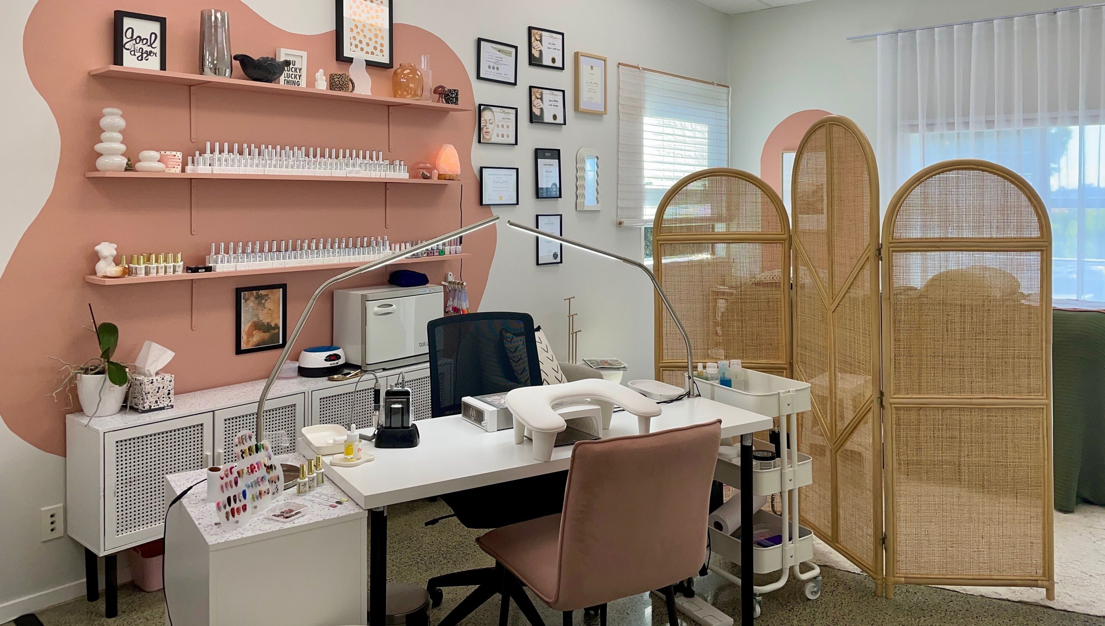 Gloss Salon's stylish nail station with pink accents in Mangawhai, Northland, NZ.