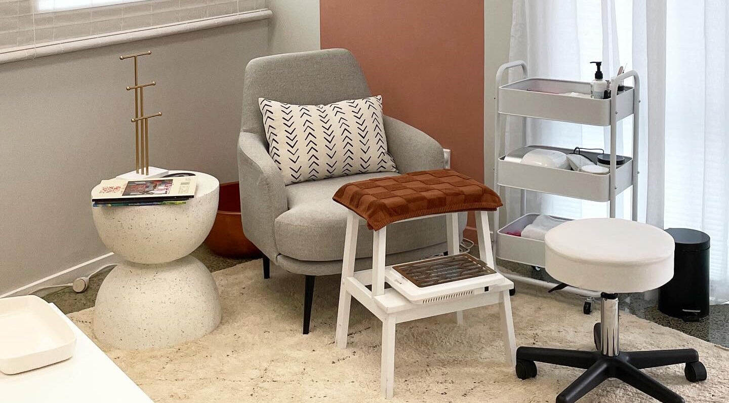 Comfortable seating area at Gloss Salon, Mangawhai, Northland, NZ, with a modern chair and accessories.