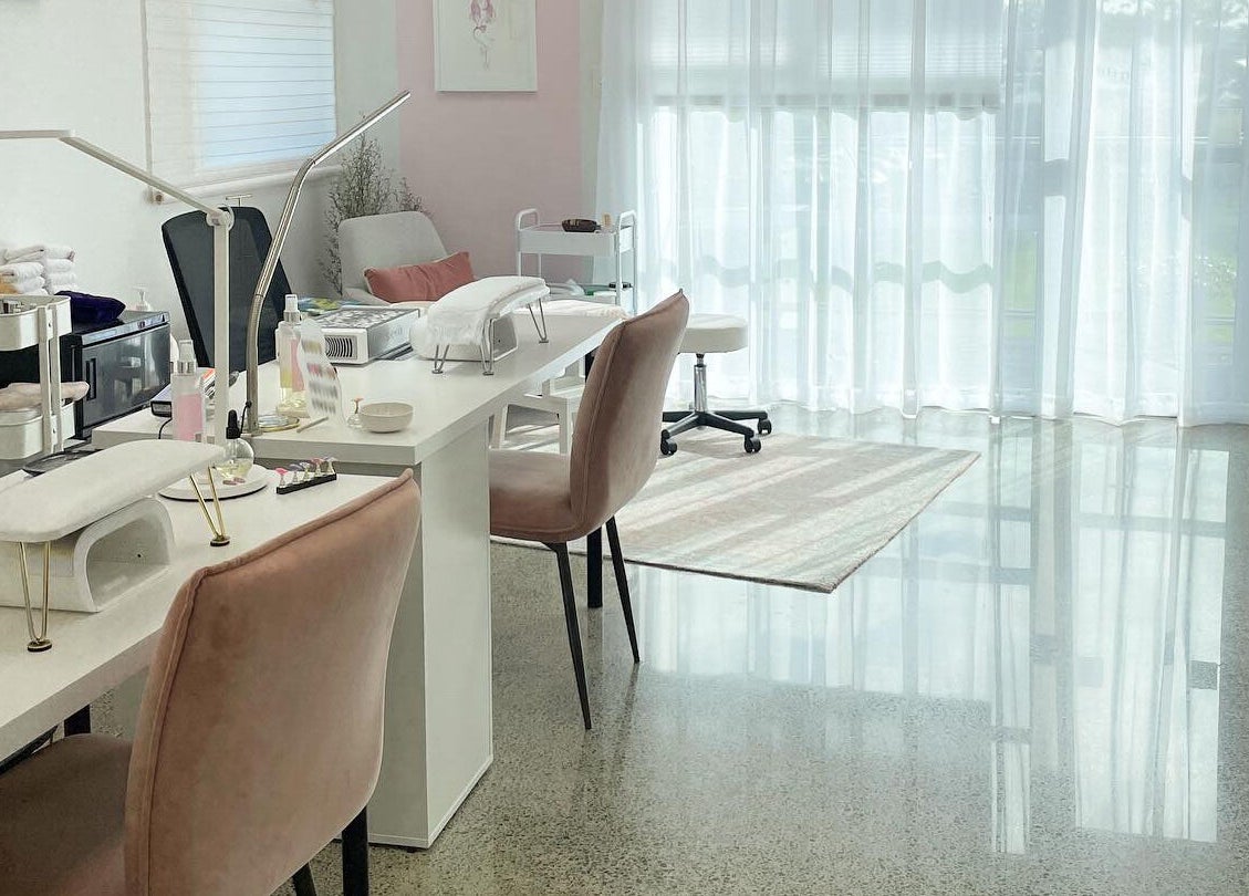 Bright manicure station at Gloss Salon, Mangawhai, Northland, NZ, with plush chairs and natural light.