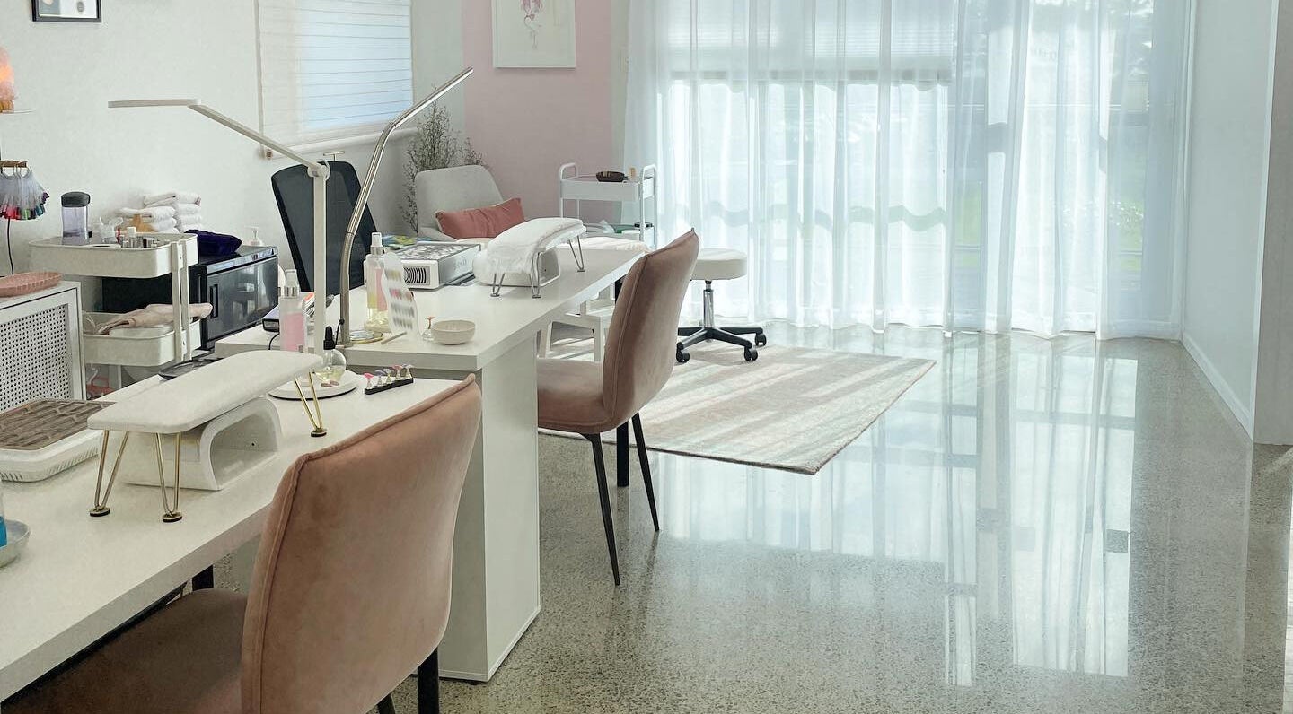 Bright manicure station at Gloss Salon, Mangawhai, Northland, NZ, with plush chairs and natural light.