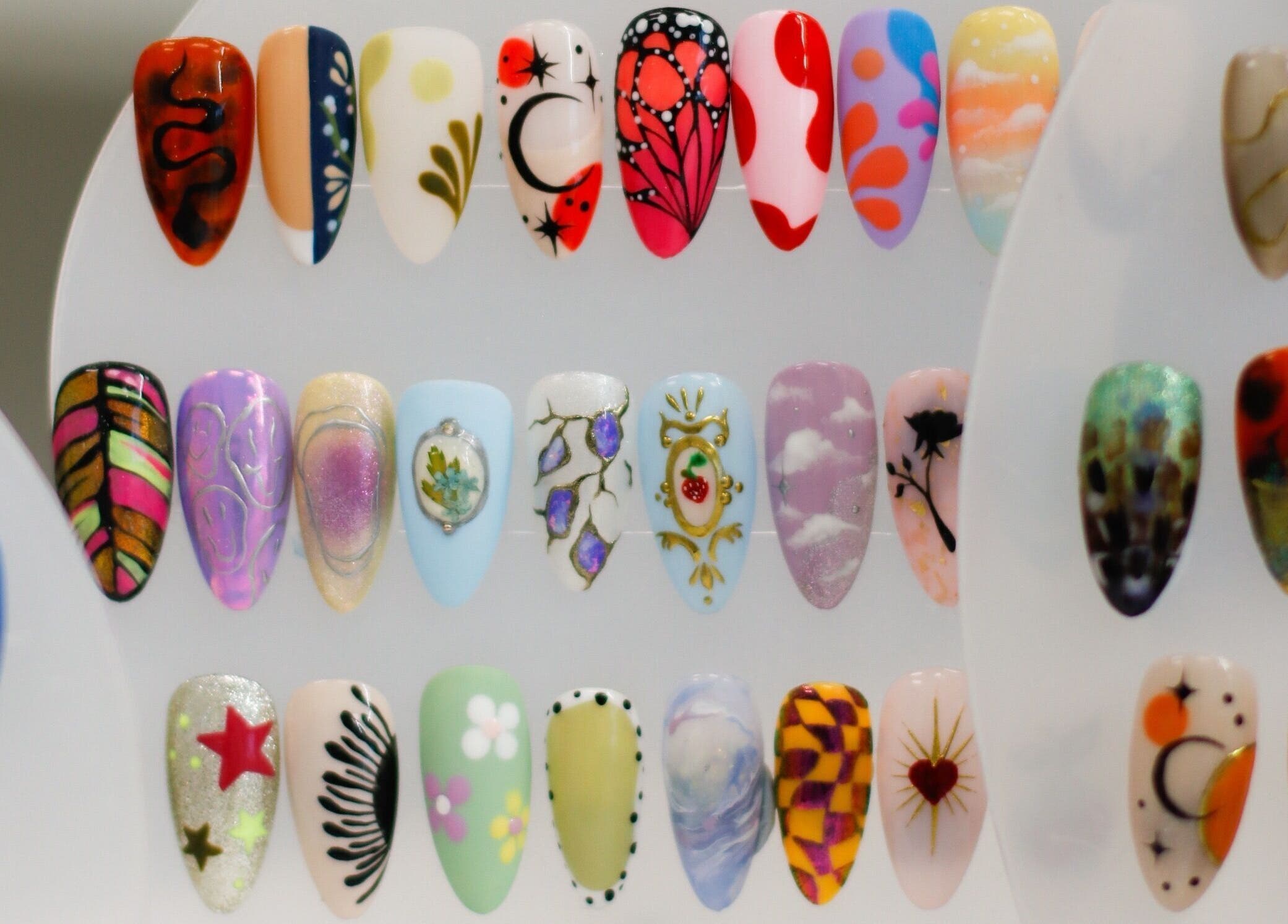 Intricately designed nail art samples at Gloss Salon, Mangawhai, Northland, NZ, showcasing diverse patterns.