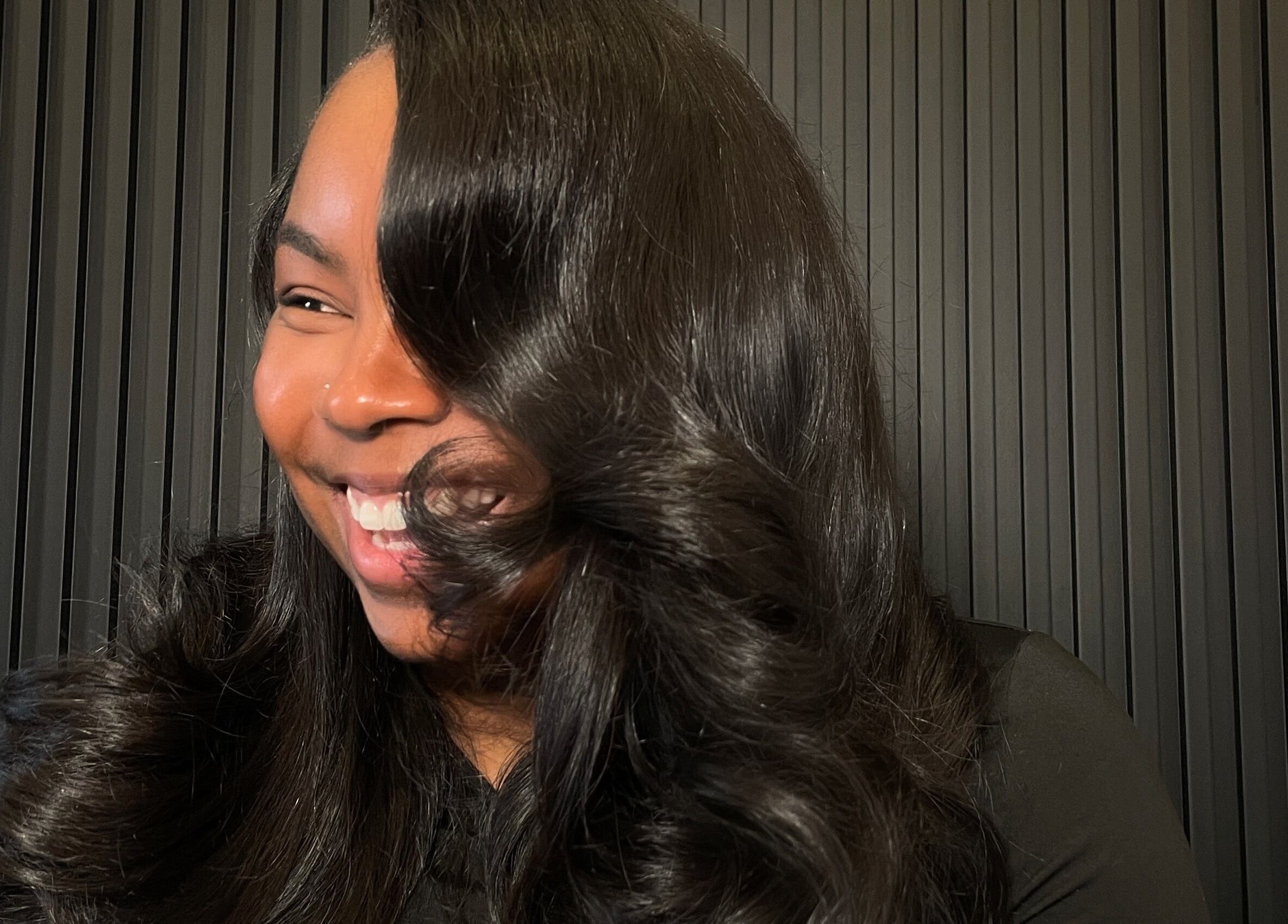 Une femme souriante avec des cheveux élégants chez CreationSanon, Saint-laurent, Québec, CA.