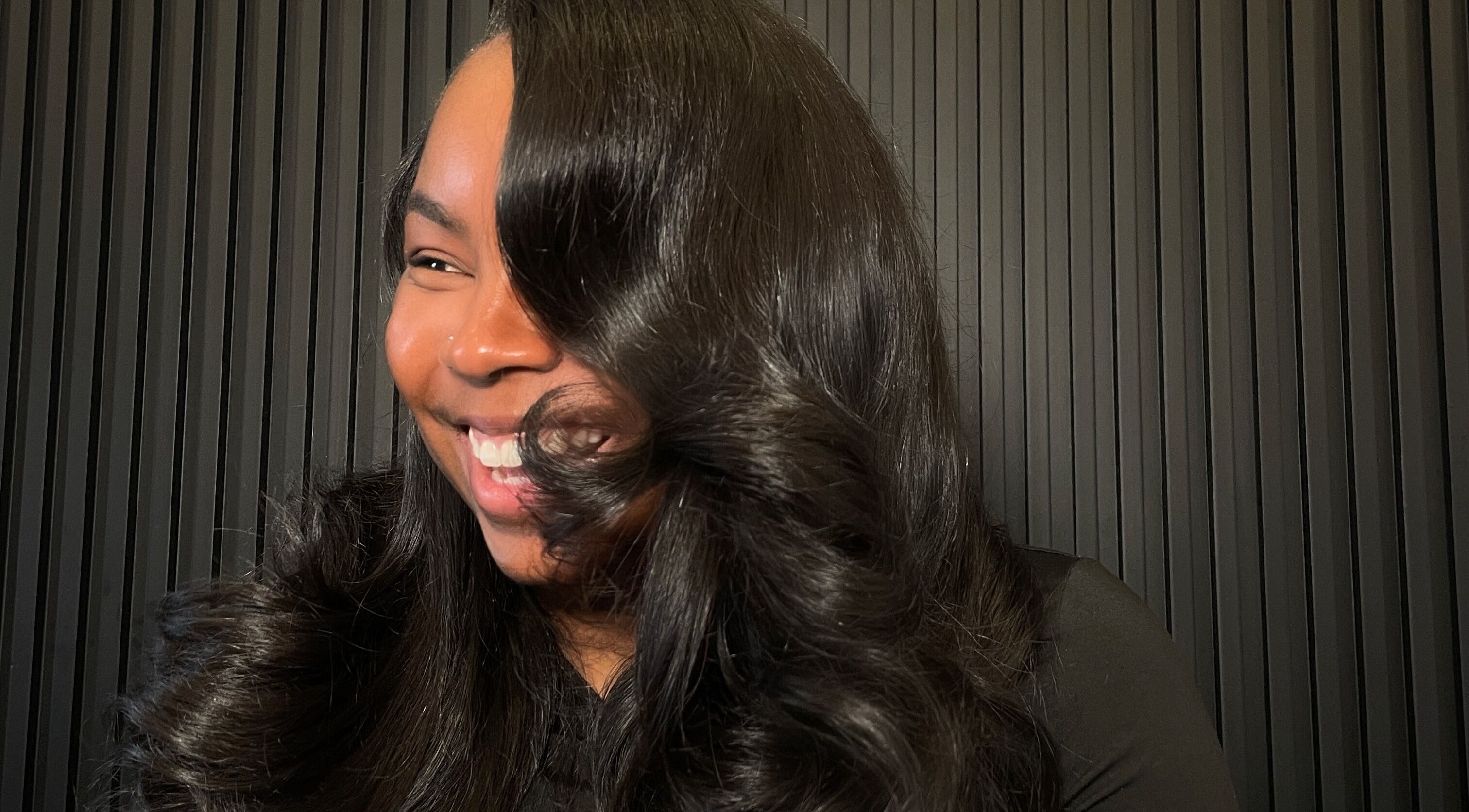 Une femme souriante avec des cheveux élégants chez CreationSanon, Saint-laurent, Québec, CA.