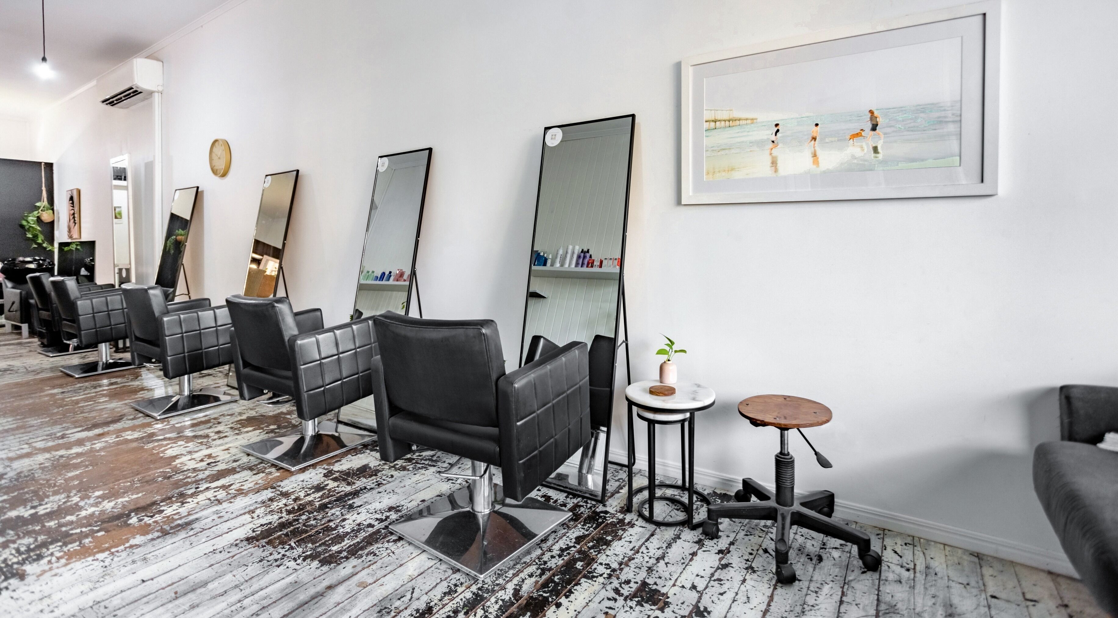 Chic salon interior of Encore Hair in Ipswich, Queensland, AU with black chairs and large mirrors.