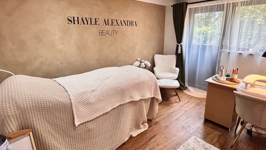 Relaxing beauty room at Shayle Alexandra Beauty in Camberley, England. Cozy bed and elegant decor.