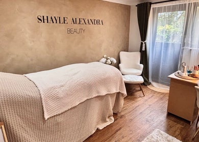 Relaxing beauty room at Shayle Alexandra Beauty in Camberley, England. Cozy bed and elegant decor.