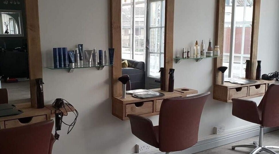 Stylish hair styling stations at The Wish Salon in Fincham, England, GB with elegant mirrors and salon products.