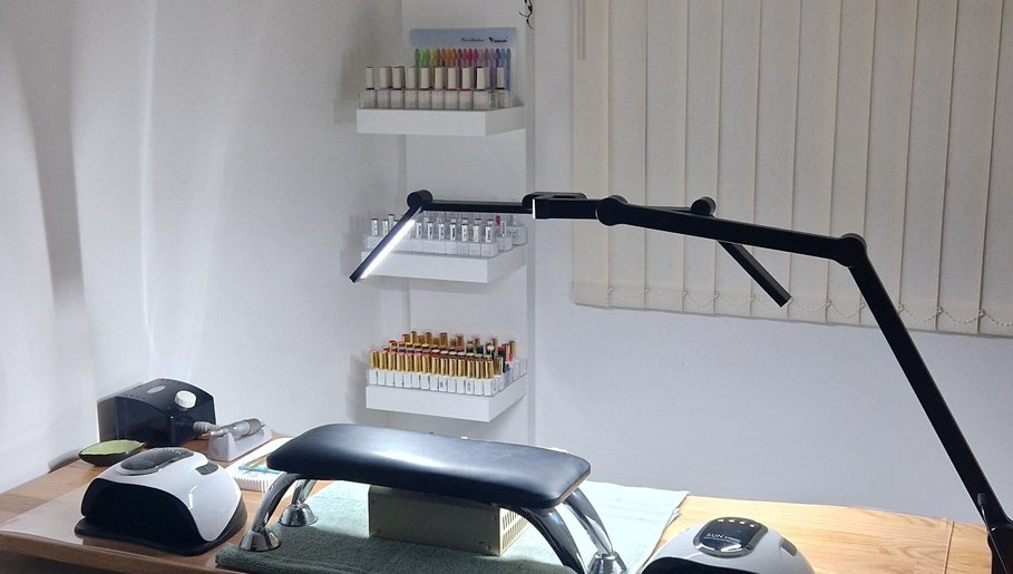 Modern nail station at Ria Dharni, Crawley, England, GB, featuring organized shelves with nail polish colors.