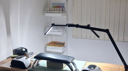 Modern nail station at Ria Dharni, Crawley, England, GB, featuring organized shelves with nail polish colors.
